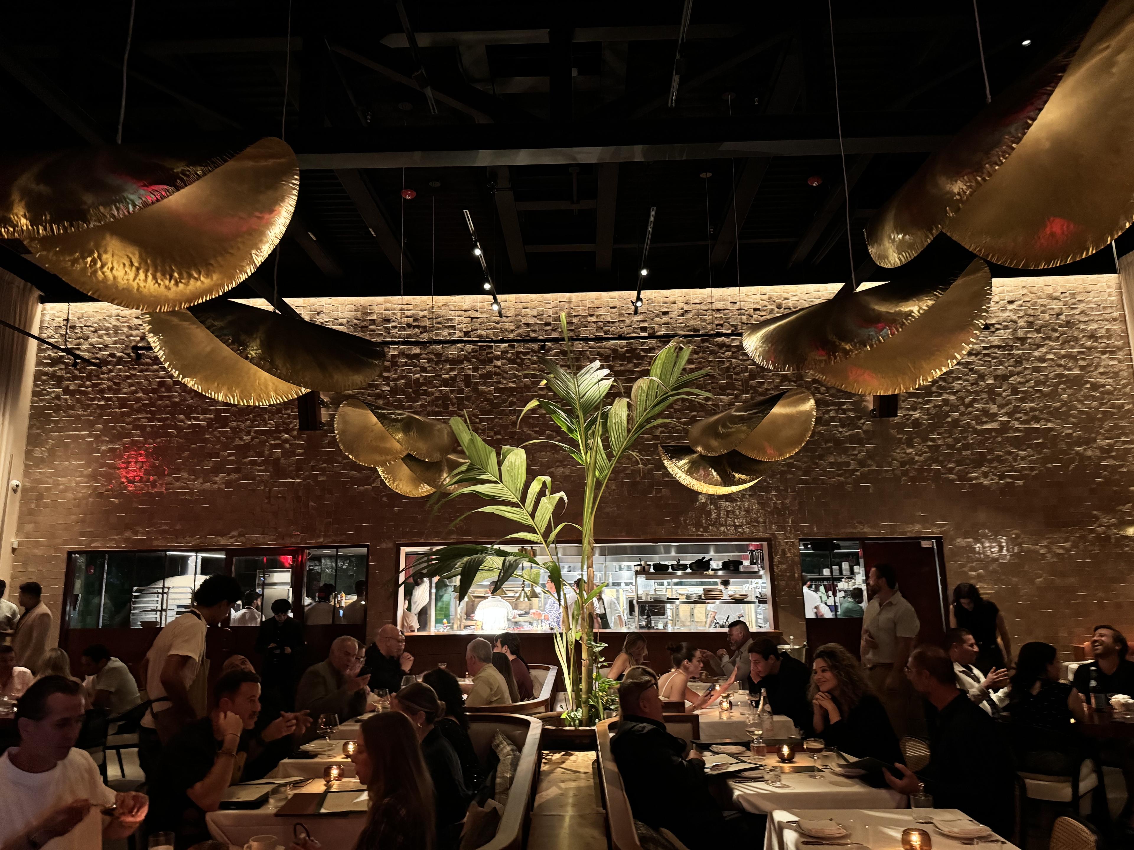 dark busy restaurant with open kitchen in back