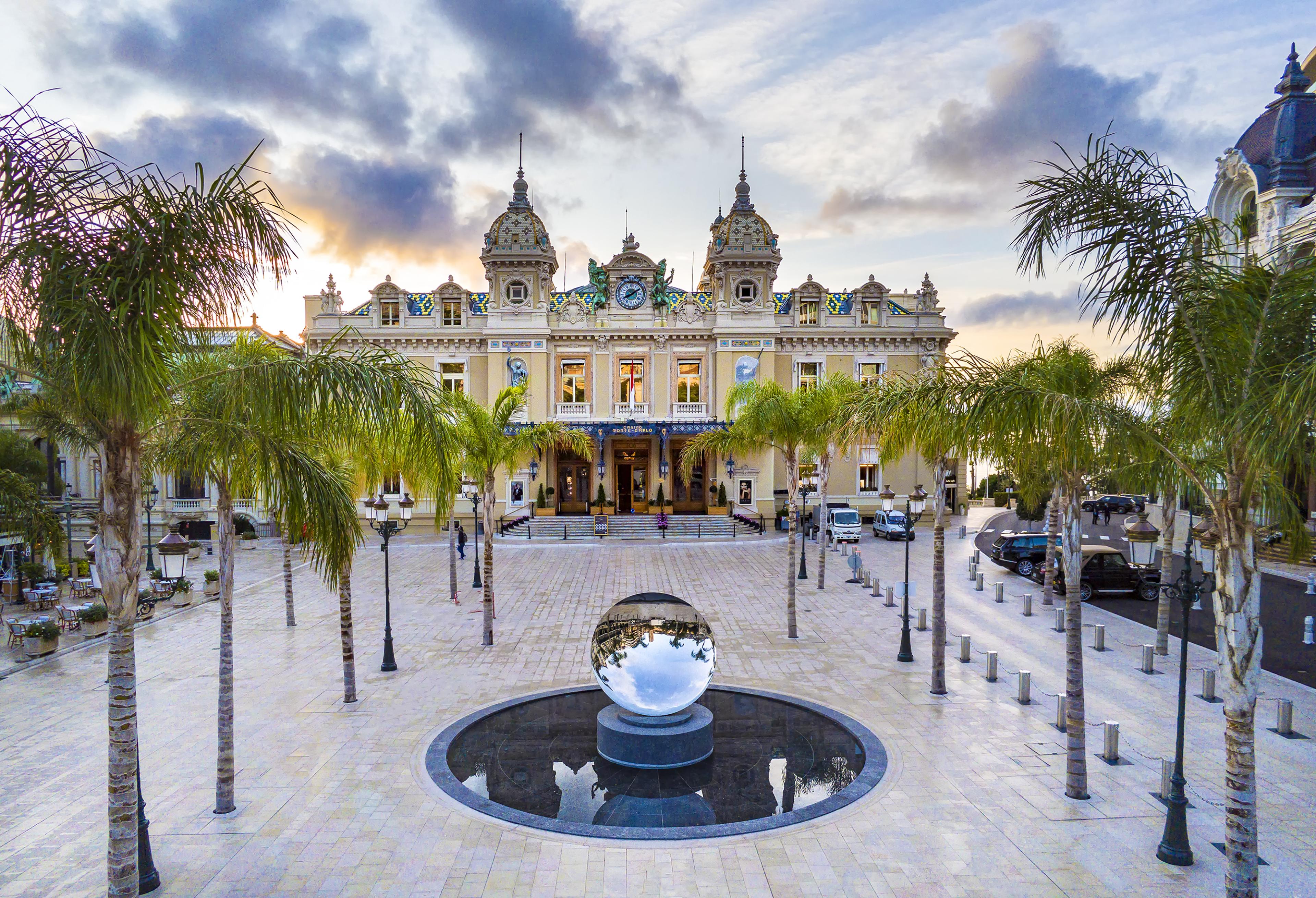 place du casino in monaco with the grand casino seen in background of plaza with palm trees