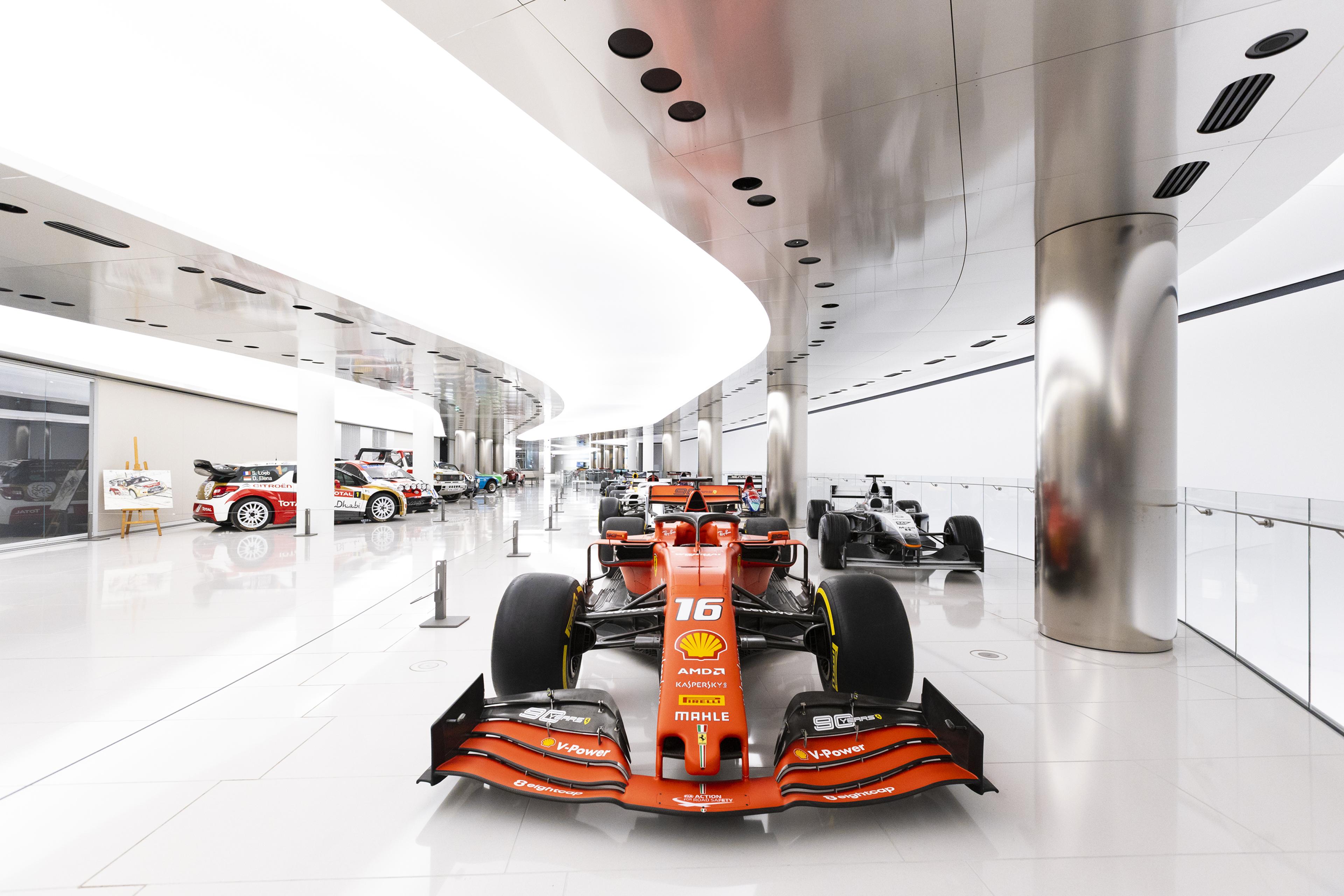 supercars and sports cars on display in a modern museum