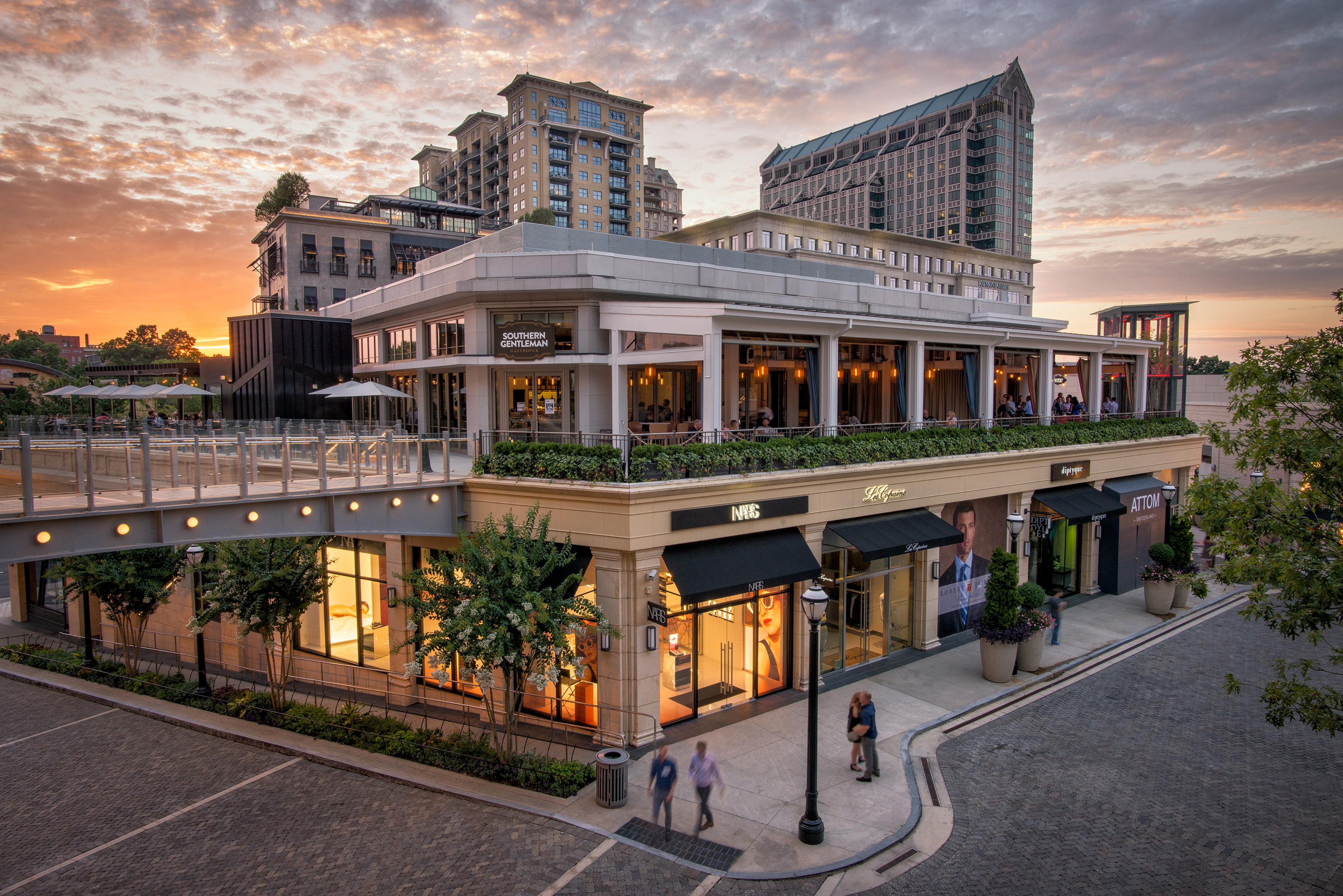 luxury shopping center exterior with balcony at sunset