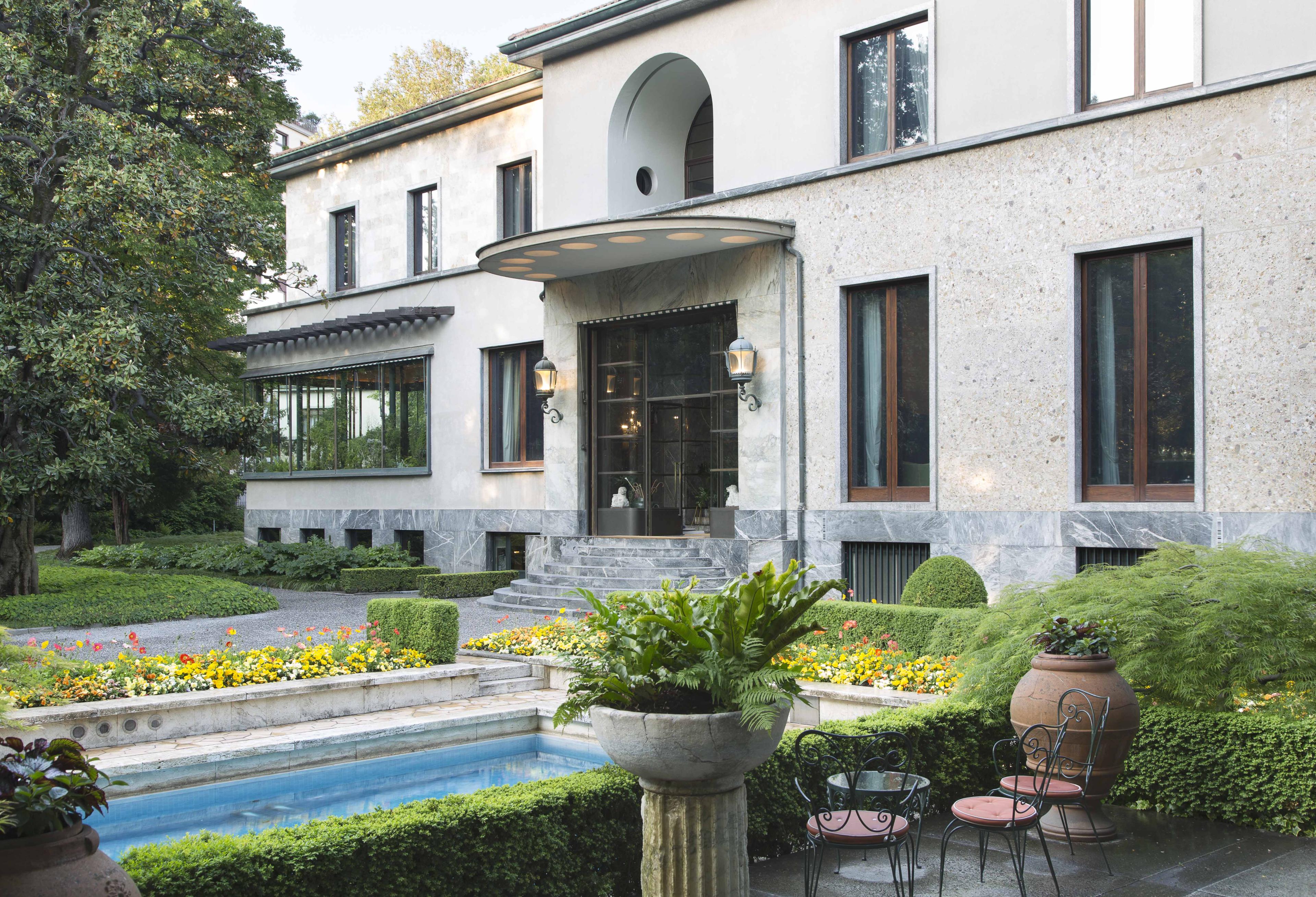 Exterior of compound with a pool in front.