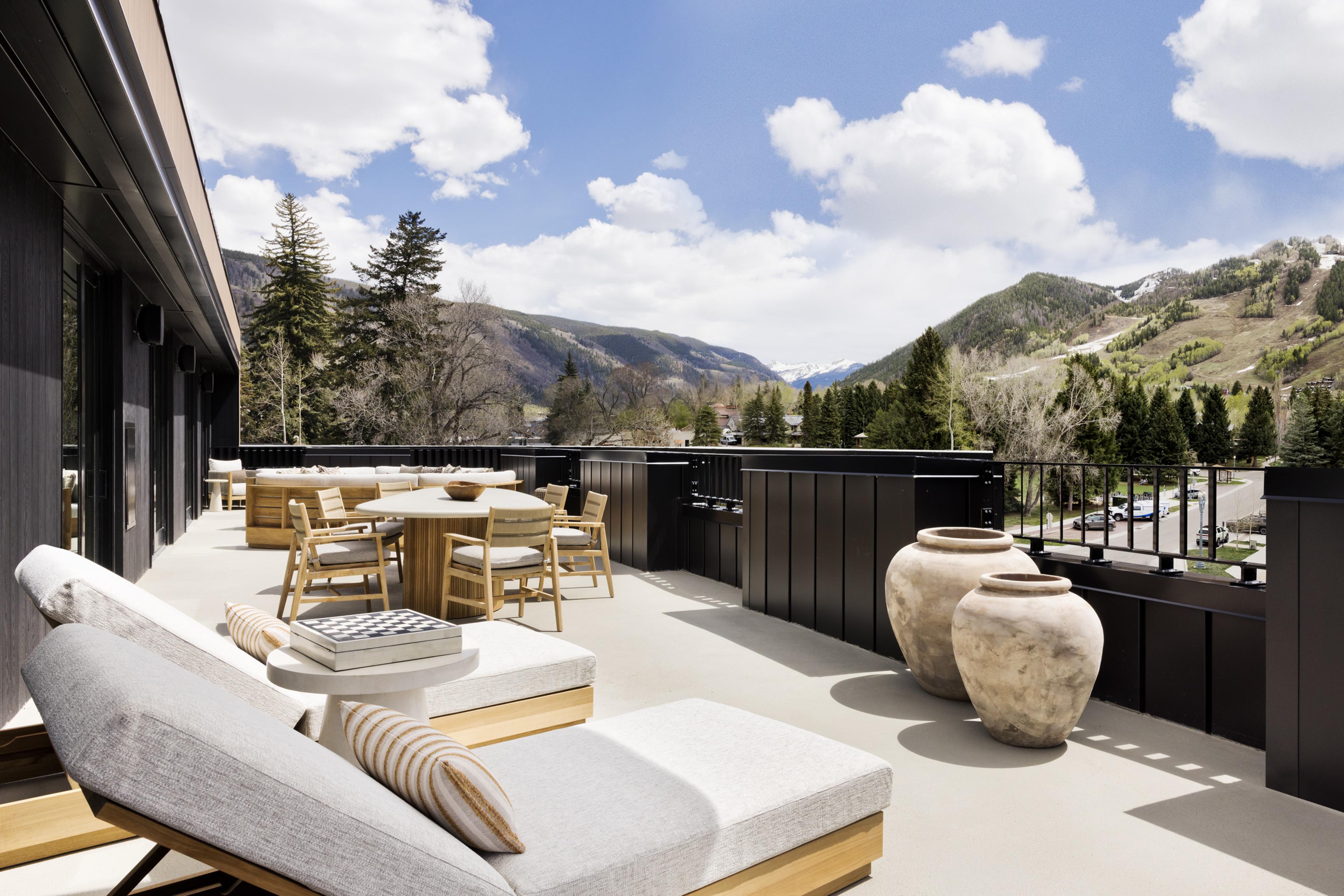 A terrace by the mountains with lounge chairs in the sun 