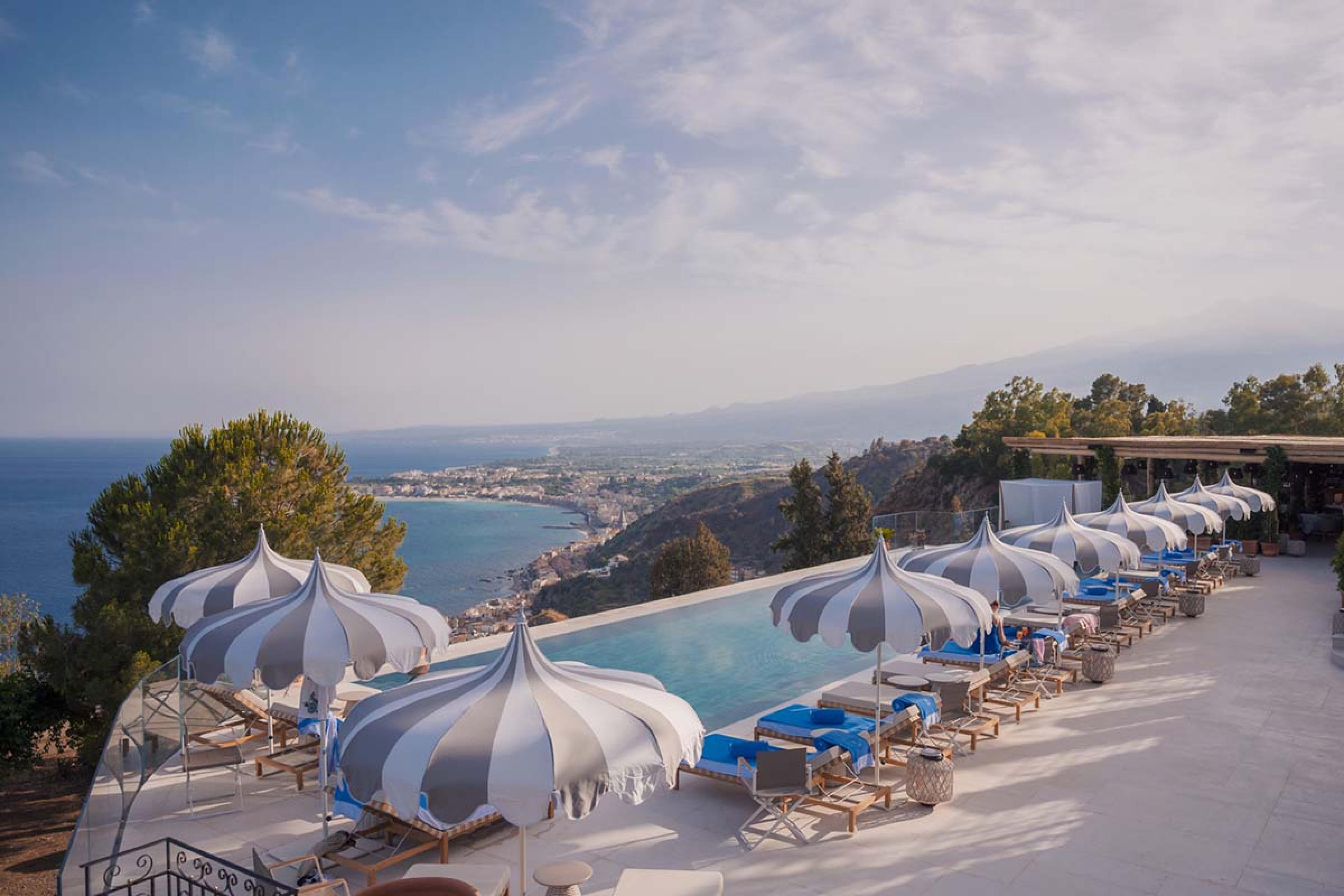 pool with daybeds and umbrellas looking over the bay