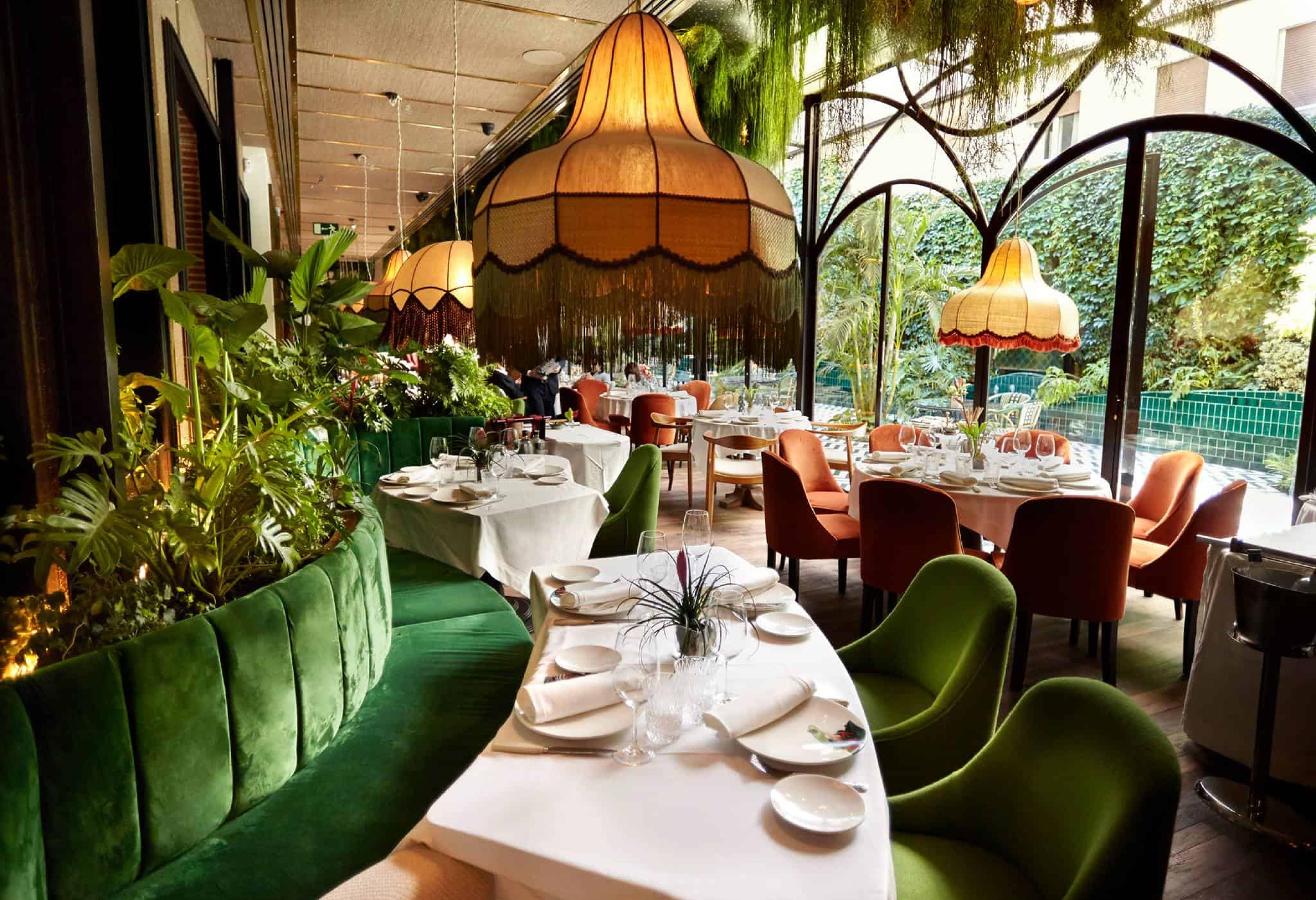 green booth and chairs along white curving tables in a jungle themed dining room