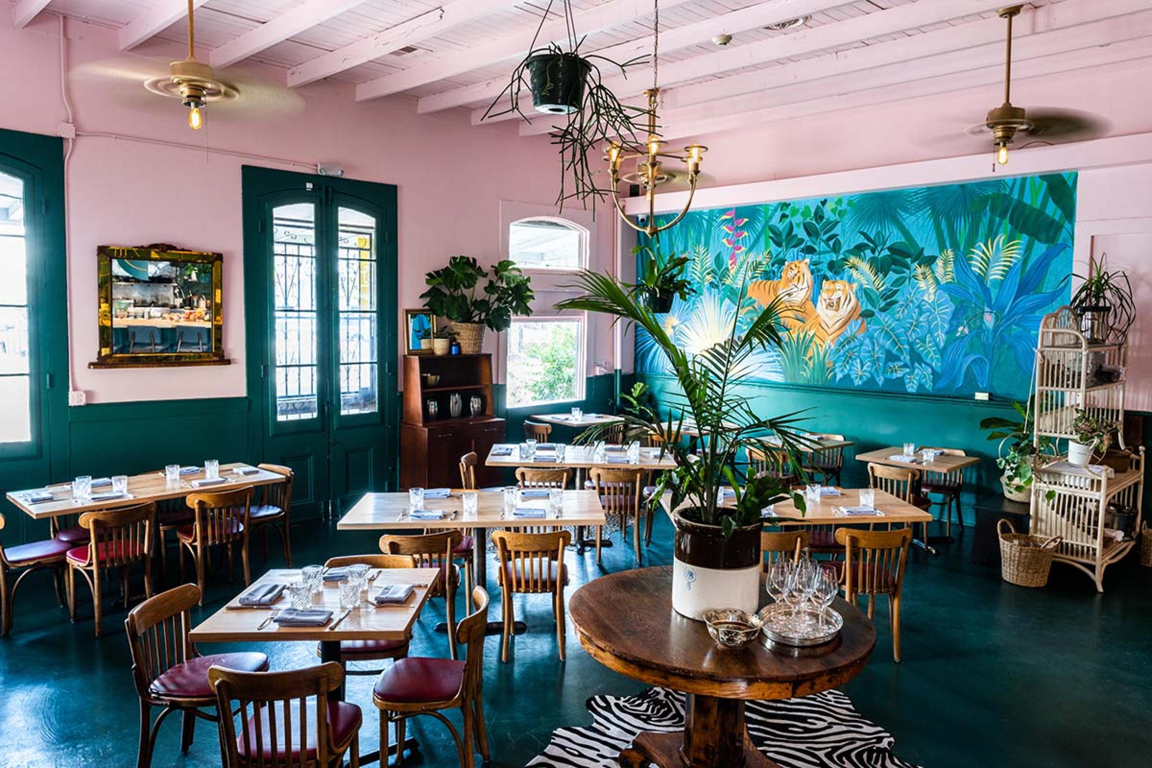 dining room with pastel pink walls and a colorful blue mural