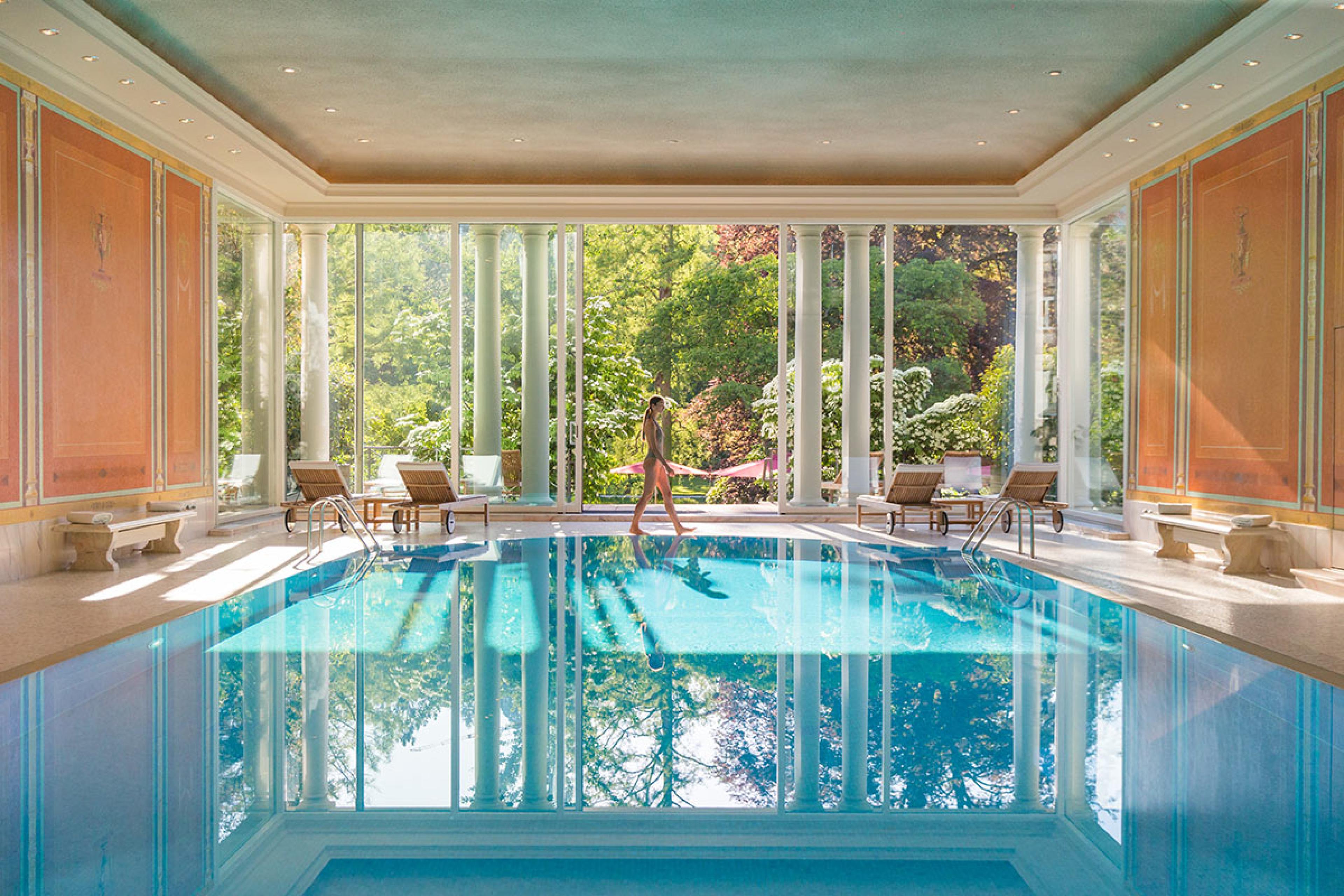 Brenners Park Hotel Spa Villa Stephanie Pool with a woman walking on the deck