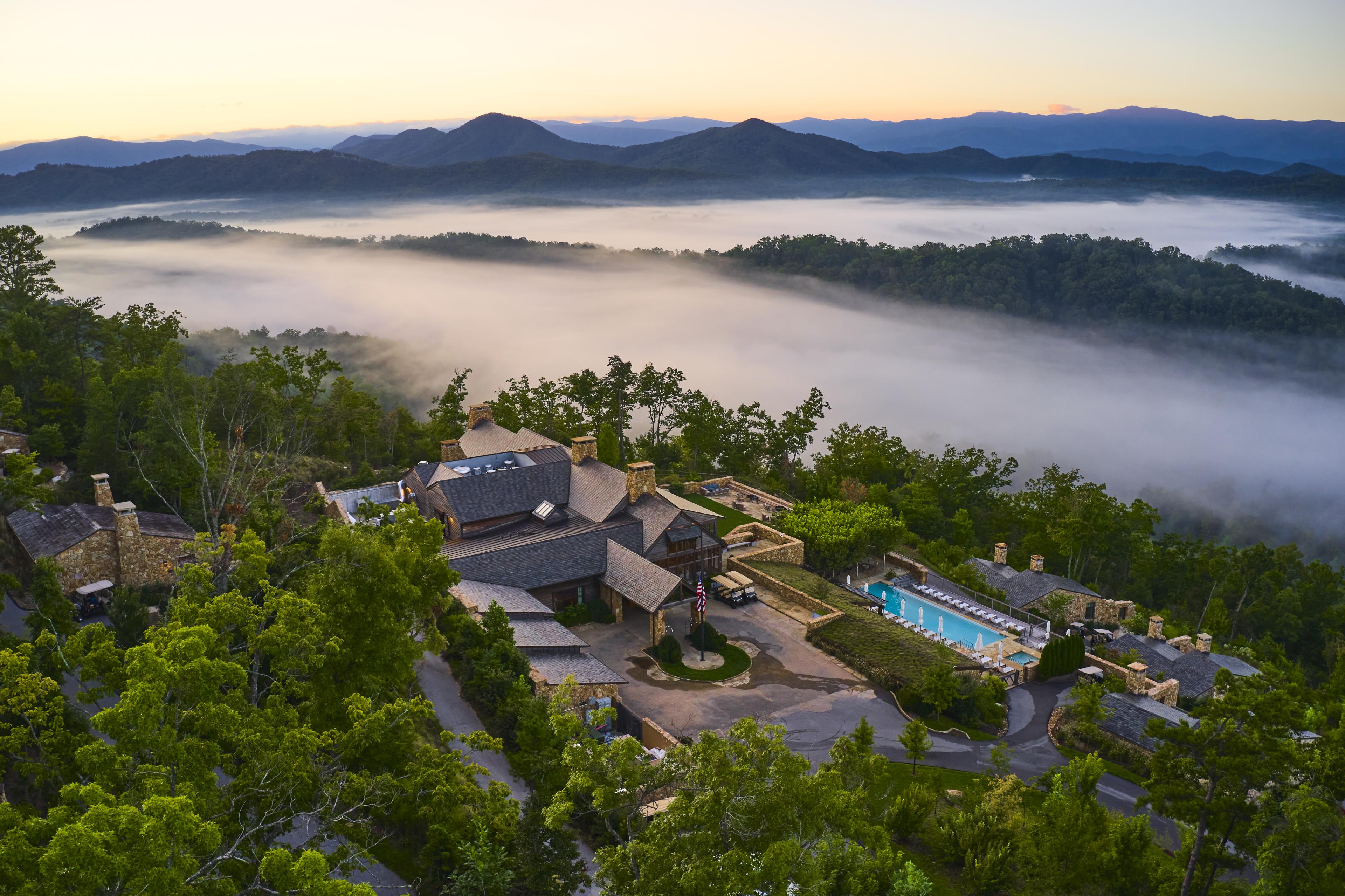 aerial view of a hotel with a pool in the mountains