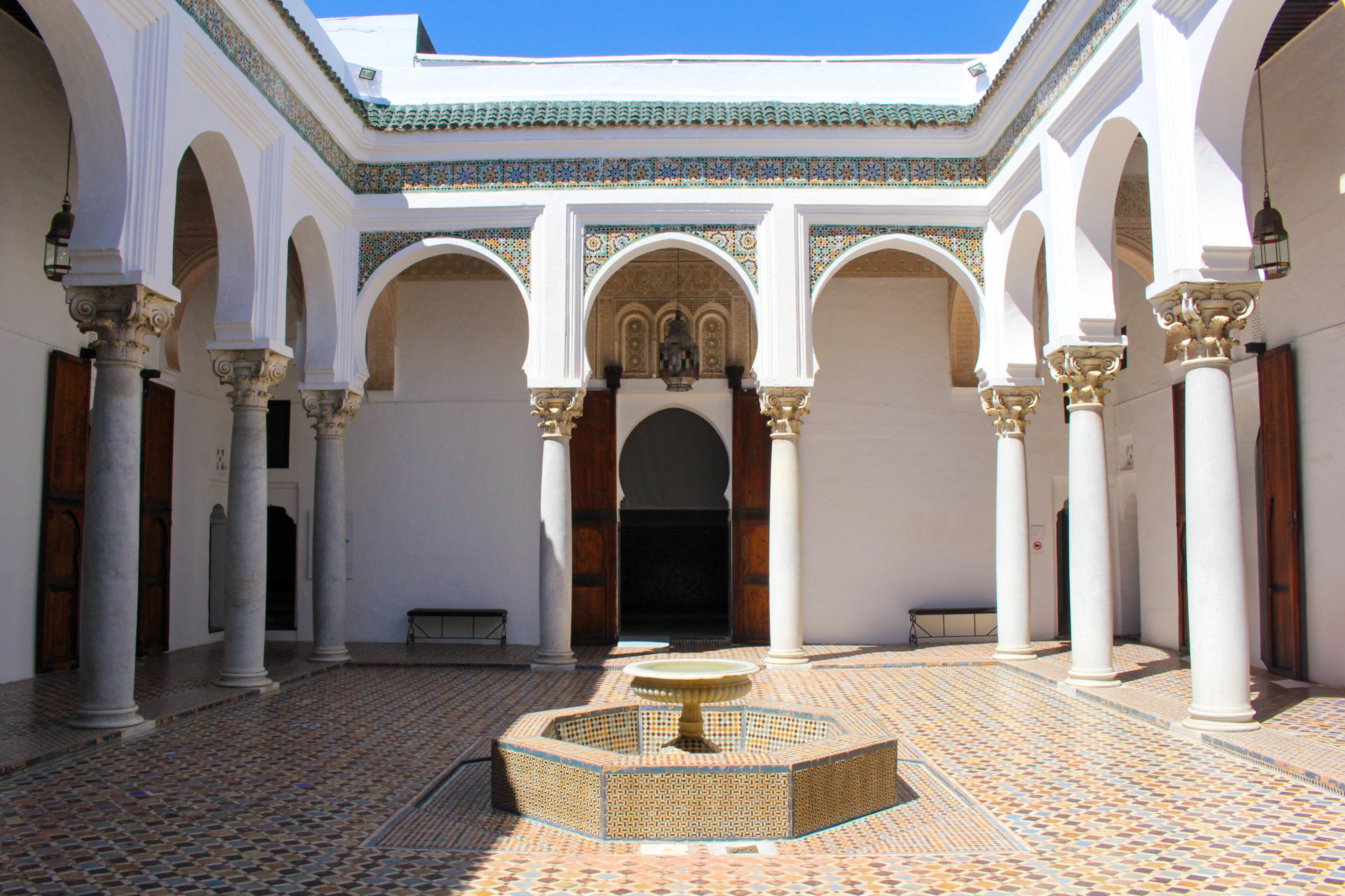 courtyard with tiles and fountain in the middle surrounded by white walls