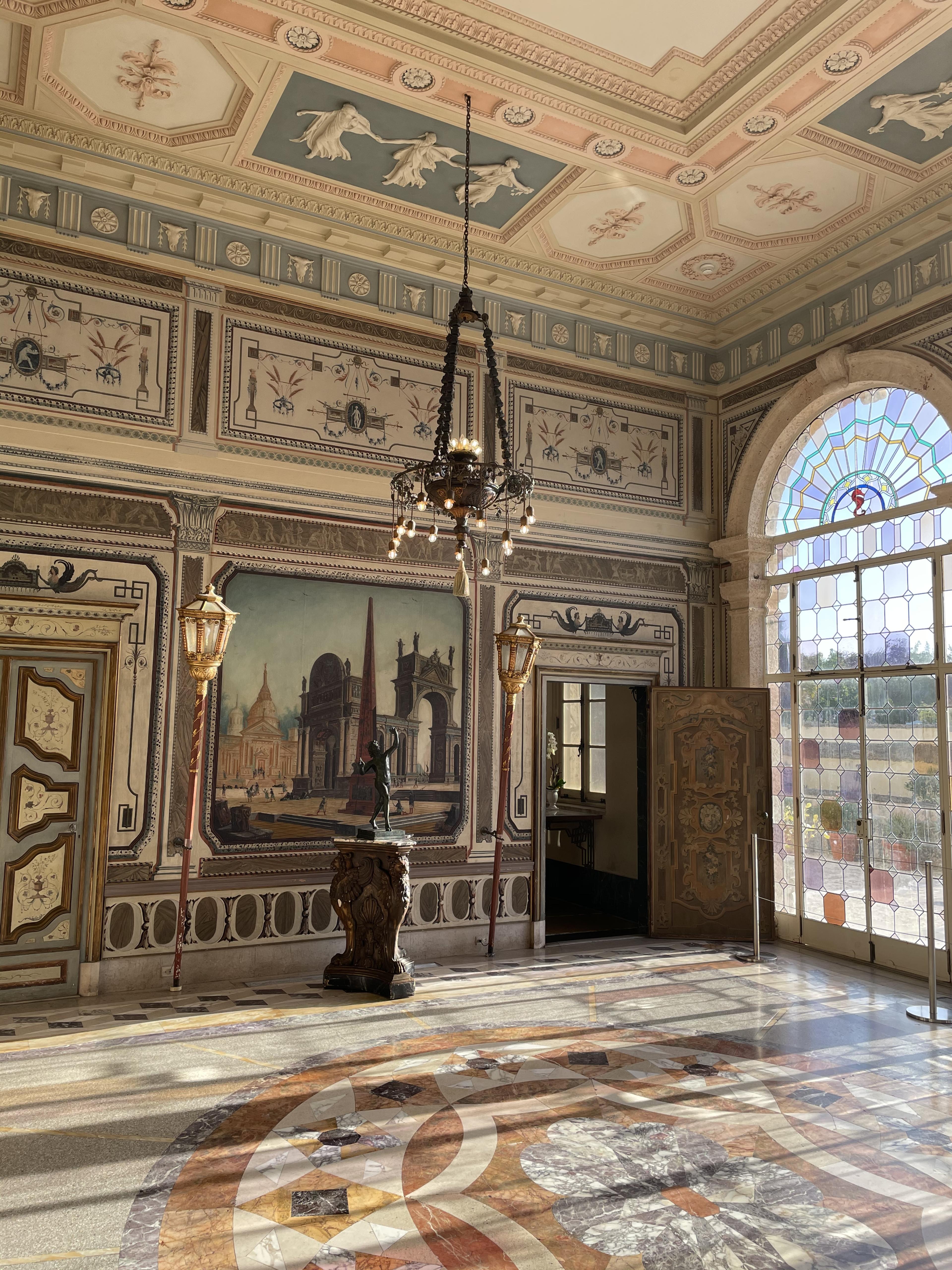 ornate italianate room with marble floors and stained glass window wall