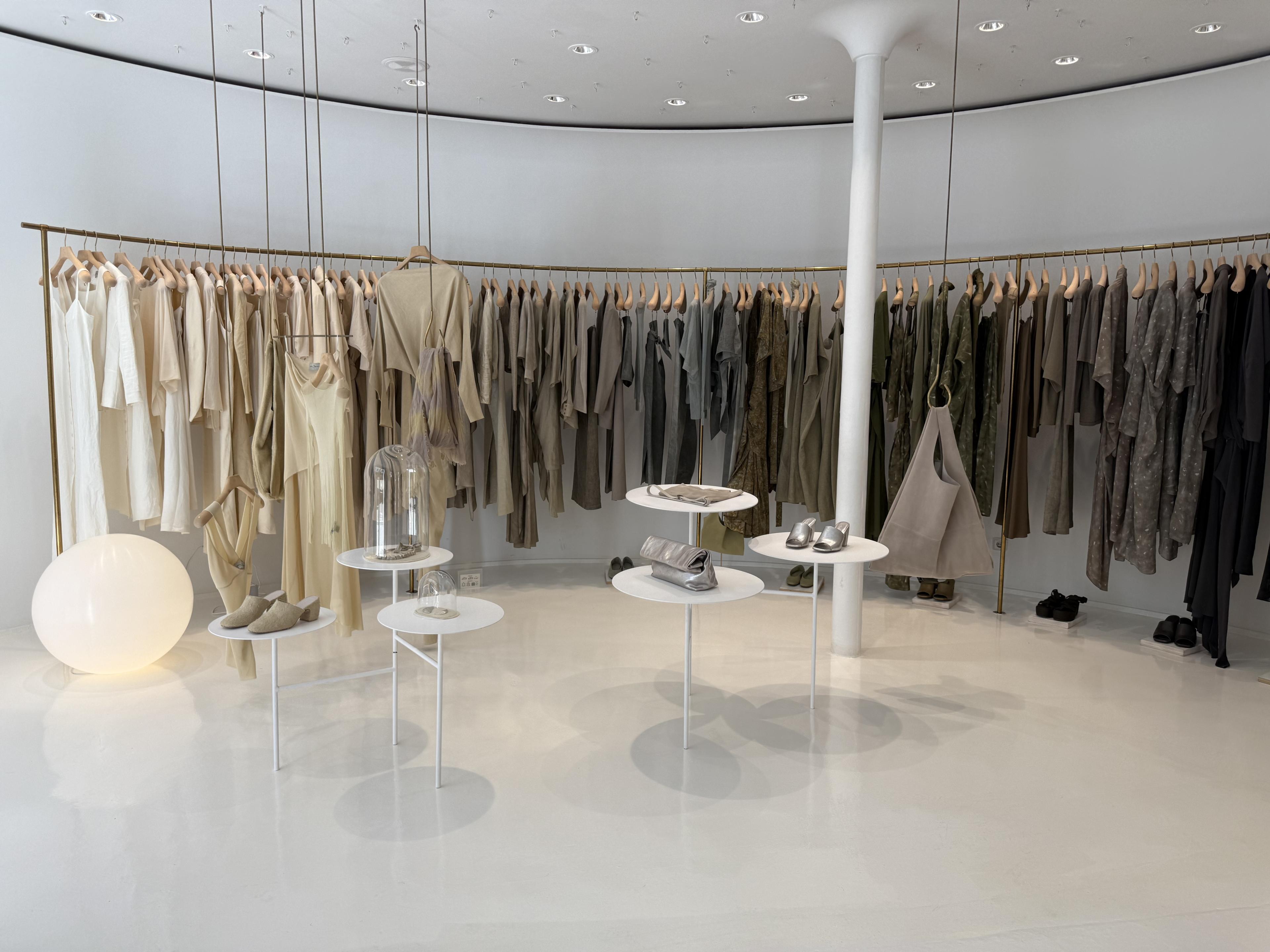 racks of neutral tone clothes hanging in a shop