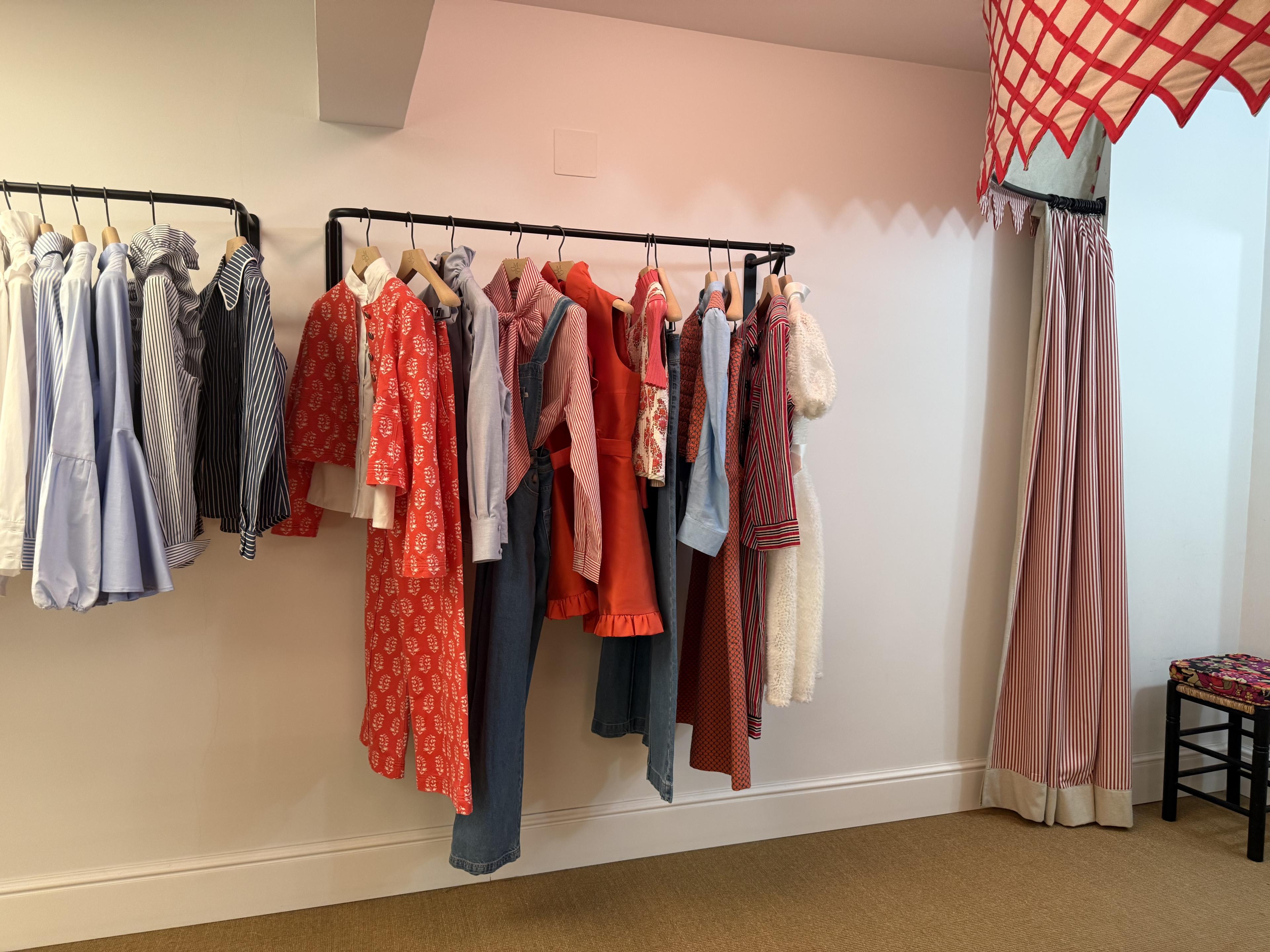 colorfully designed clothes hang off a rack