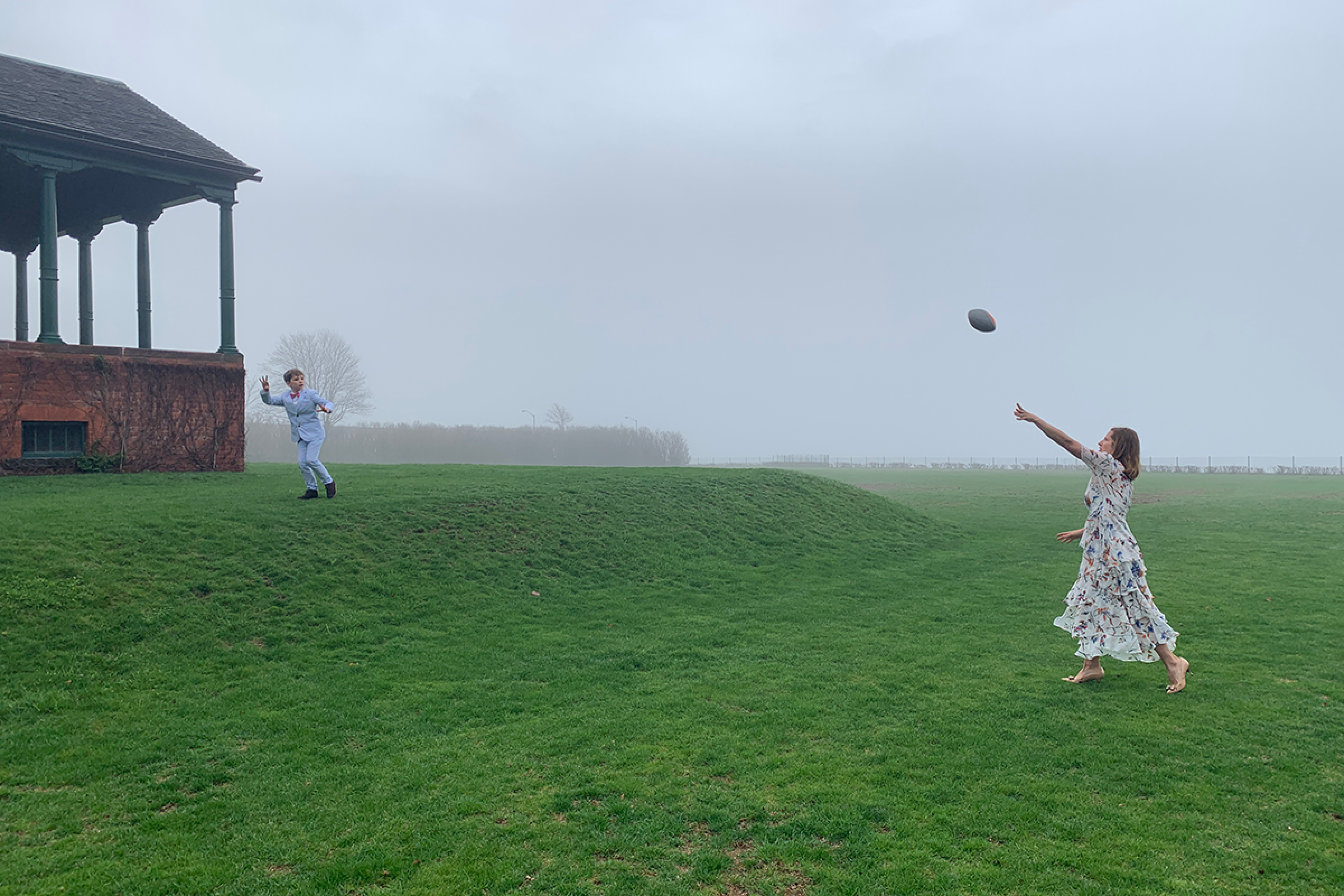 Family playing football in yard