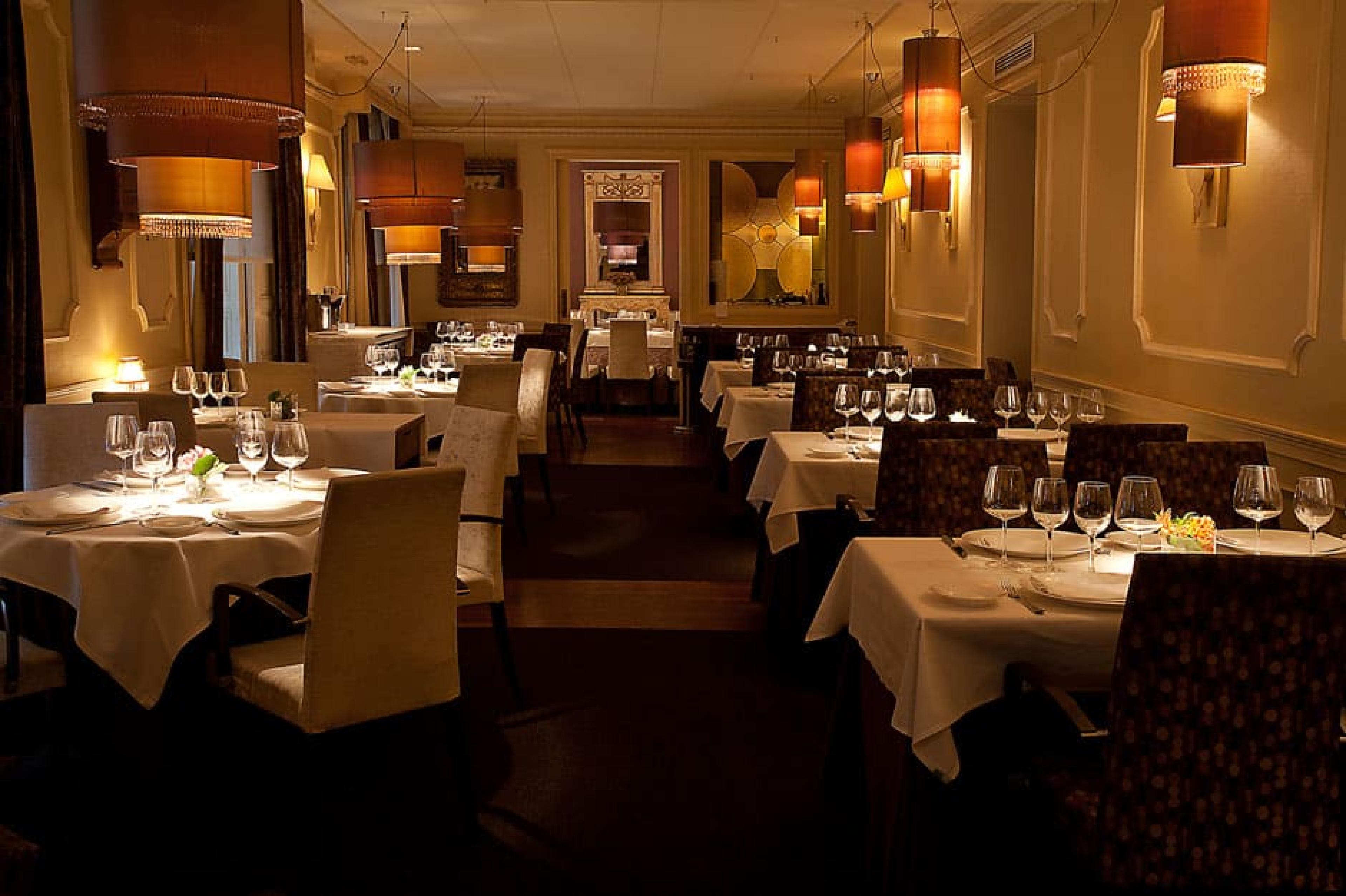dimly lit dining room with separated rows of tables 